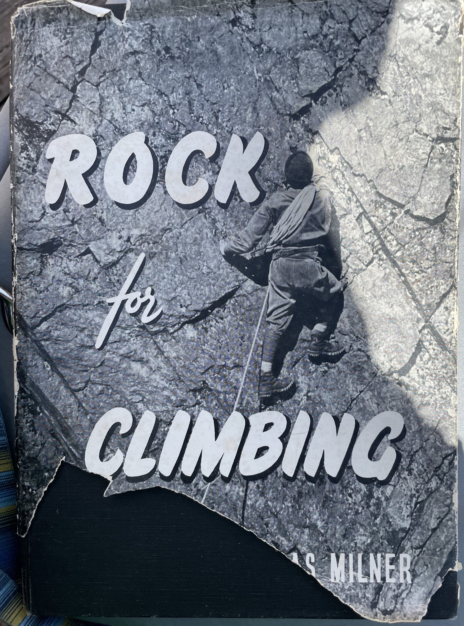The cover of the Rock for Climbing book, with a torn corner, showing a picture of a person climbing